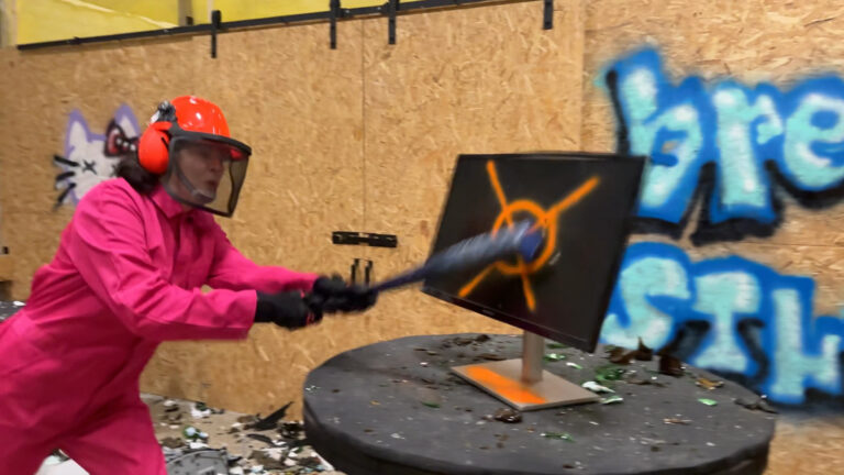 Vrouw slaat een computerscherm kapot in The Rage smash room Eindhoven